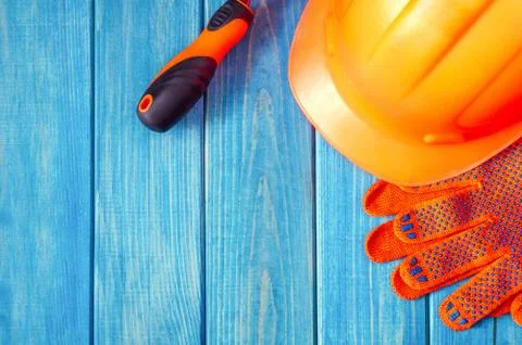 Orange hard hat and tool on wooden vintage blue boards Stock Photos