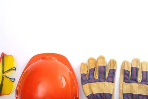 Orange hard hat, leather work gloves and safety glasses on a white background Stock Photos