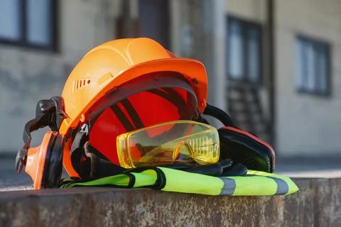 Orange hard hat with protective goggles, earmuffs and high visibility vest .. Stock Photos