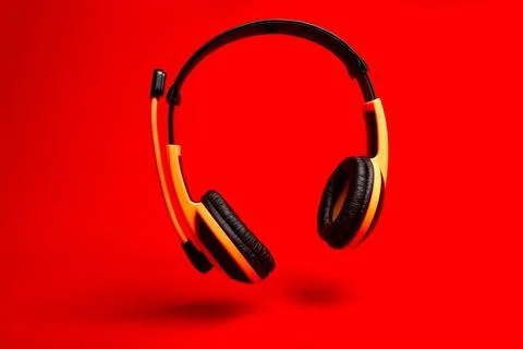 Orange headset on red background Stock Photos
