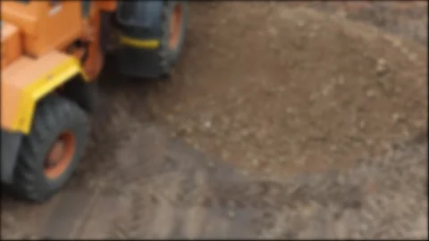 Orange heavy construction machinery moving dirt pile at construction site on Stock Footage 344863971