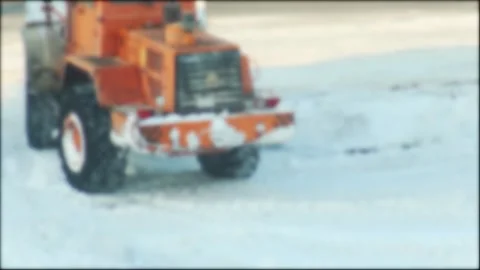 Orange heavy duty loader with snow plow attachment removing thick layer of fresh Stock-Footage 328359470