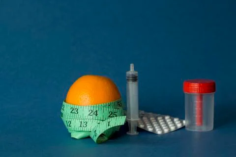 Orange with an inch lying on blue background Stock Photos