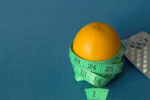 Orange with an inch lying on blue background13 Stock Photos