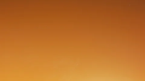 Orange ink diffusing in water Stock Footage 100023359