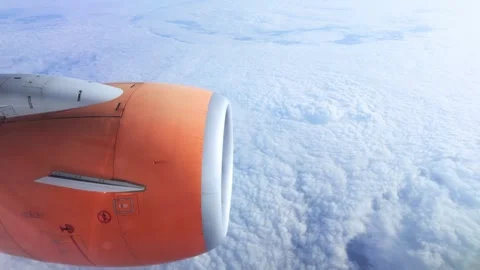 Orange jet engine cowling on passenger airplane flying high Stock Footage 346664890