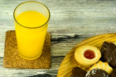 Orange juice and different types of cookies Stock Photos