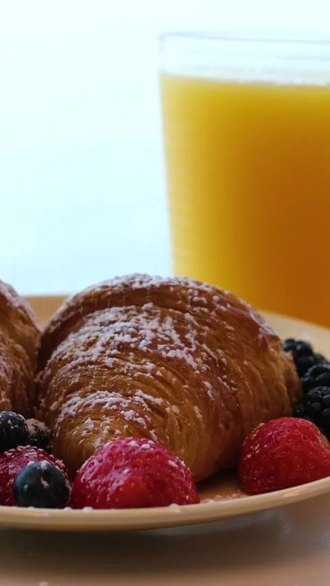 Orange juice breakfast Overhead shot of a hand grabbing a golden pretzel Stock Footage 317701693