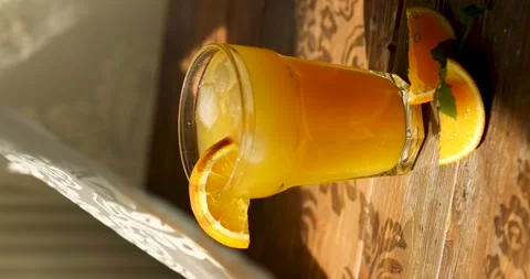Orange juice in a glass on the table by the window Stock Footage 246001706