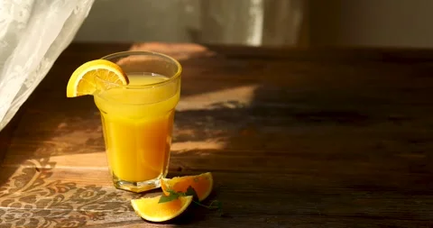 Orange juice in a glass by the window Stock Footage 246001741