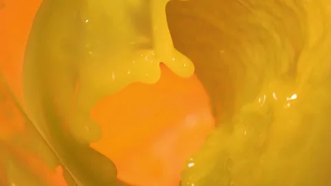 Orange juice pours into a glass, creating an wave against a yellow background. Stock Footage 328094635