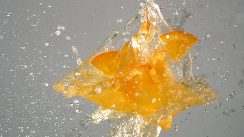 Orange juice with sliced oranges exploded and splashed in the air. Slow Motion. Video stock 128772924