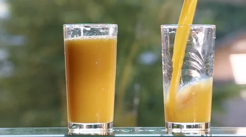 Orange juice on the table,on green background. Video stock 51690034
