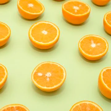 Orange juicy oranges split in half on green Stock Photos