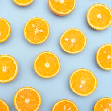 Orange juicy oranges split in half on blue Stock Photos