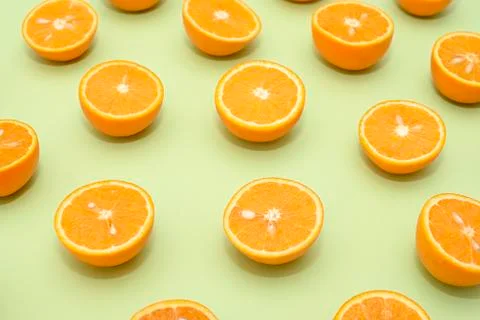 Orange juicy oranges split in half on green Stock Photos
