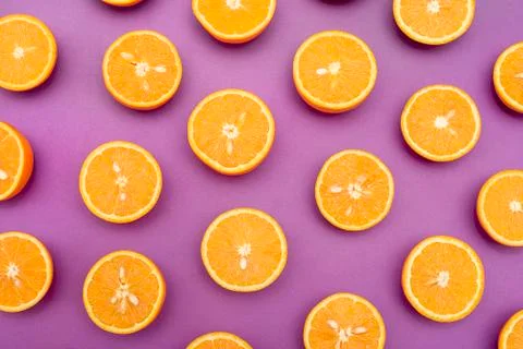 Orange juicy oranges split in half on purple Stock Photos