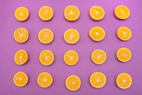 Orange juicy oranges split in half on purple Stock Photos