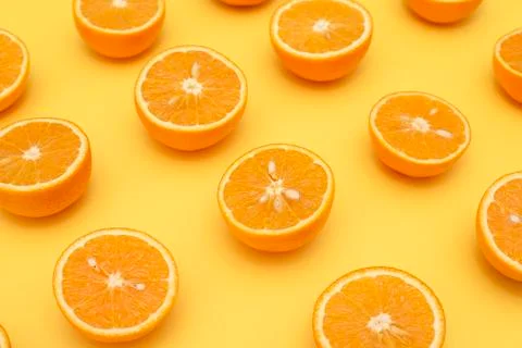 Orange juicy oranges split in half on yellow Stock Photos