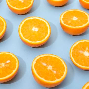 Orange juicy oranges split in half on blue Stock Photos