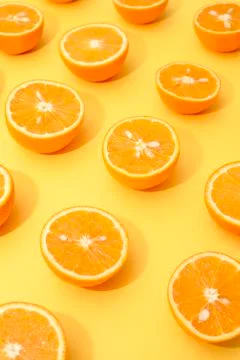 Orange juicy oranges split in half on yellow Stock Photos