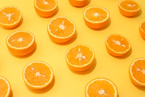Orange juicy oranges split in half on yellow Stock Photos