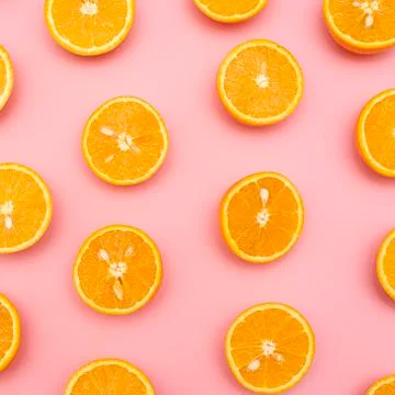 Orange juicy oranges split in half on pink Stock Photos