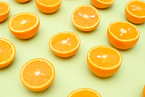 Orange juicy oranges split in half on green Stock Photos