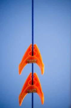 Orange laundry hooks on the wire.on a blue sky background Stock Photos