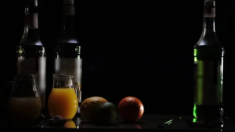 Orange, lemon, lime and 3 bottles of syrup stand on the table. Stock Footage 93970577