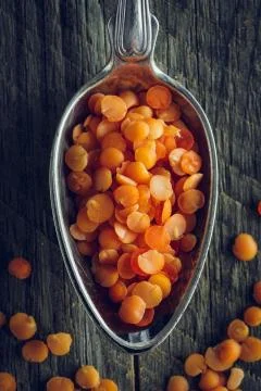 Orange lentils in a spoon Stock Photos