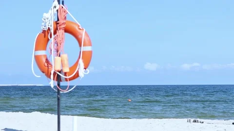 Orange lifebuoy ring circle on beach blue sea, sky scenery background, sunny day Video stock 196226643