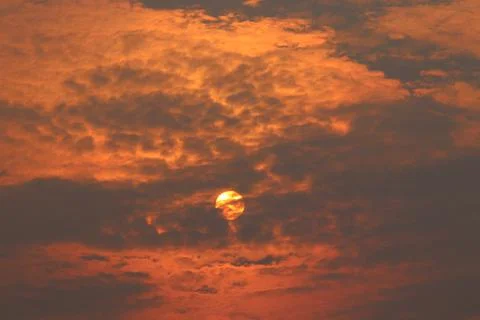 Orange light on cloud and sun with gray cloud cover sun. Stock Photos