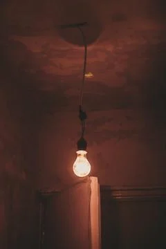 Orange lightbulb hanging from the ceiling Stock Photos