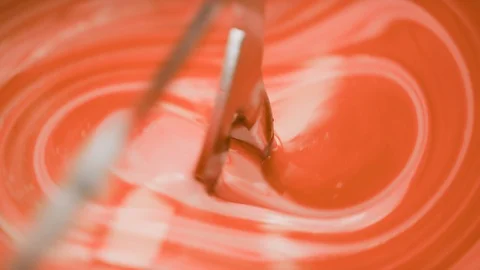 Orange liquid is added into lab blender to a white cream at the lab Stock Footage 100749245