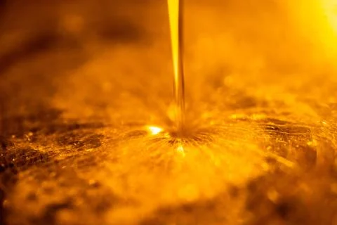 Orange liquid and viscous stream of motorcycle motor oil like a flow of honey Fotos Stock