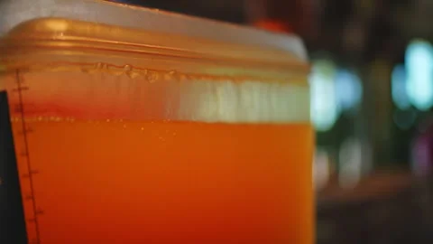 Orange Liquid in Clear Dispenser - Refreshing Drink Video stock 332458514