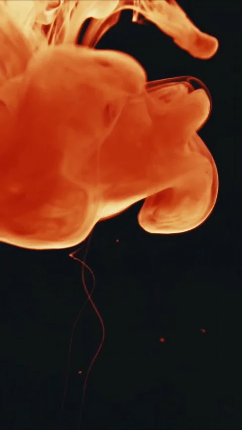 Orange liquid ink drops falling and swirling in clear water against a solid Stock-Footage 347692279