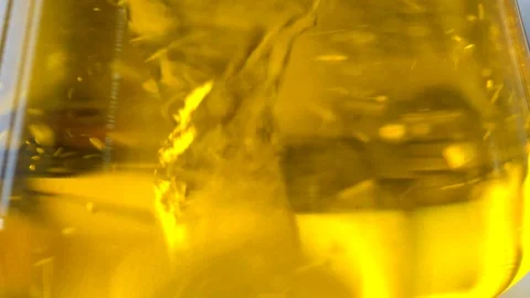 Orange liquid mixed inside a flask at a supplement laboratory, close up Stock Footage 101229563