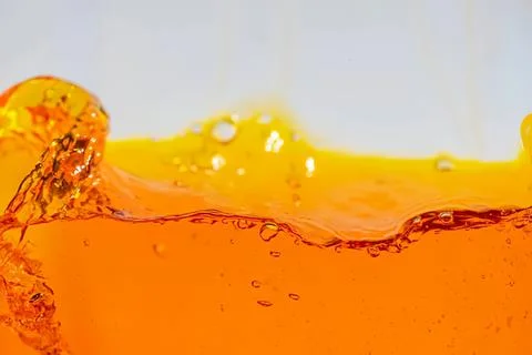 Orange liquid splash in motion with bubbles and waves Stock Photos