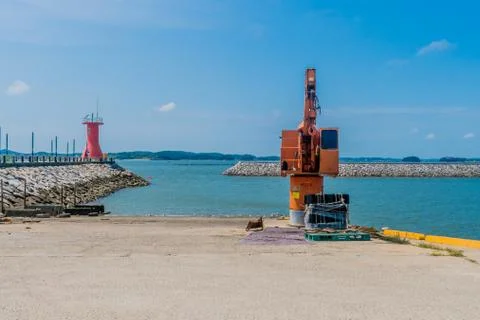 Orange loading crane on concrete dock Stock Photos