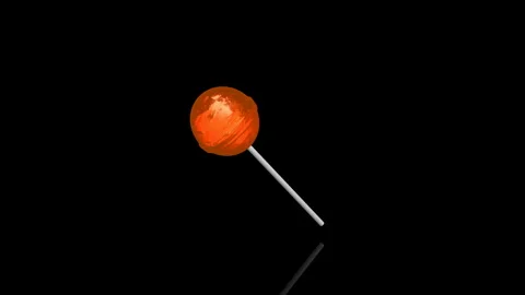 Orange Lollypop turns on itself - loop animation - black background Stock Footage 255459334