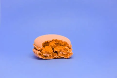 Orange macaron on a violet background. fresh delicious dessert. Stock Photos