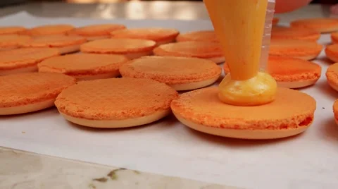 Orange Macarons halves coated with cream Vídeos de archivo 62426293