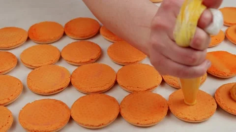Orange macaroon halves coated with cream Stock Footage 62426126