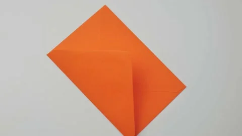 Orange mail envelope rotates on a white plate, top view Stock Footage 156201554