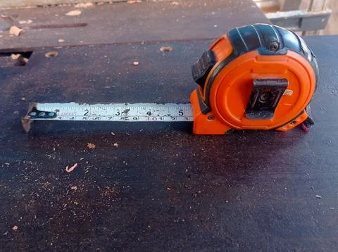 Orange meter roll placed on a brown metal table Stock Photos