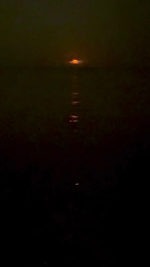 Orange moon reflecting on dark ocean water at night Stock Footage 331976406