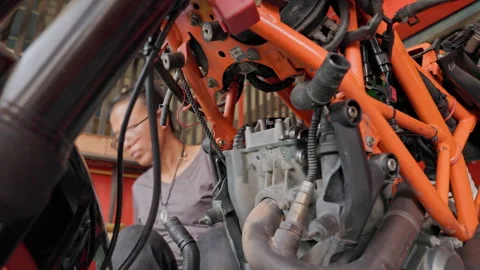 Orange Motorcycle Engine Revival: 50 Year Old Asian Lady at Work Mastering the Stock Footage 257596767