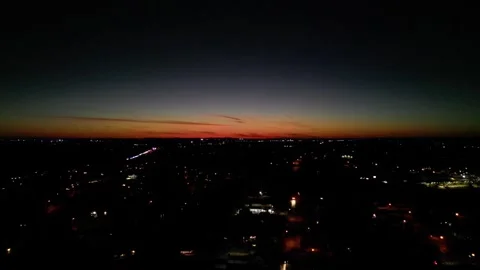 Orange Night Sky Drone Orbit and Sink over Main Street with Cars going by Stock Footage 292670906